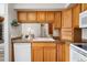 A tidy kitchen features wood cabinets, light countertops, and appliances set for an eat in kitchen area at 13635 E Yale Ave # D, Aurora, CO 80014
