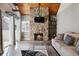 Bright living room with a striking stone fireplace, vaulted wooden ceiling and sliding glass door at 13635 E Yale Ave # D, Aurora, CO 80014