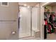 Clean bathroom featuring a modern shower with a glass door next to an organized closet at 155 S Monaco Street Pkwy # 311, Denver, CO 80224