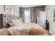 Bright bedroom with a large bed, neutral walls, and cozy curtains framing a window at 155 S Monaco Street Pkwy # 311, Denver, CO 80224