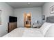 Serene bedroom features a TV, light gray walls, and a glimpse into the ensuite bathroom at 155 S Monaco Street Pkwy # 311, Denver, CO 80224