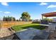 Manicured backyard featuring green grass, a wooden fence, mature trees, and a patio area at 5611 S Sicily Cir, Aurora, CO 80015