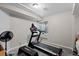Finished basement area featuring a treadmill, exercise equipment, and a window for natural light at 5611 S Sicily Cir, Aurora, CO 80015