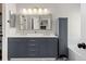 Contemporary bathroom with double vanity, modern lighting, and a standalone storage cabinet at 5611 S Sicily Cir, Aurora, CO 80015