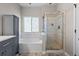 Bright bathroom features a tub, frosted window, and a glass enclosed shower at 5611 S Sicily Cir, Aurora, CO 80015
