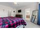 Bedroom with a plaid comforter, dresser, and a large mirror by the wall at 5611 S Sicily Cir, Aurora, CO 80015