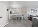 Well-lit dining area with tile floors, adjacent to the kitchen and featuring a stylish hanging light fixture at 5611 S Sicily Cir, Aurora, CO 80015