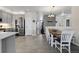 Open-concept kitchen and dining area with stainless steel appliances and light-colored flooring at 5611 S Sicily Cir, Aurora, CO 80015