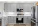 Well-lit kitchen featuring gray cabinets, stainless steel appliances, and light countertops at 5611 S Sicily Cir, Aurora, CO 80015