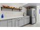 Basement kitchenette with stainless steel appliances and light gray cabinets at 5611 S Sicily Cir, Aurora, CO 80015