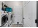Functional laundry room equipped with modern washer and dryer units and extra storage shelves at 5611 S Sicily Cir, Aurora, CO 80015