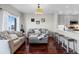 Cozy living room featuring hardwood floors, modern sofas, and an open view into the kitchen area at 5611 S Sicily Cir, Aurora, CO 80015
