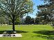 Scenic park view with lush green lawn, mature trees, picnic table, and residential buildings in the background at 7035 E 38Th Ave # 4, Denver, CO 80207