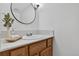 Bathroom featuring a wood vanity with a new countertop, round mirror, and updated fixtures at 70 Long Bow Cir, Monument, CO 80132