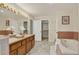 Bright bathroom featuring dual sinks, vanity, and a bathtub at 70 Long Bow Cir, Monument, CO 80132