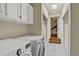 Functional laundry room with marble-look tile, built-in cabinets, and washer/dryer at 70 Long Bow Cir, Monument, CO 80132