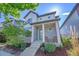 Attractive two-story home boasting a welcoming covered front porch with rocking chairs and meticulously landscaped front yard at 6632 Osage St, Denver, CO 80221