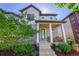 Charming two-story home featuring a covered front porch with rocking chairs and beautifully landscaped front yard at 6632 Osage St, Denver, CO 80221