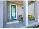 Inviting front porch features a vibrant blue door flanked by rocking chairs and classic white columns at 6632 Osage St, Denver, CO 80221