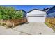 Detached two-car garage with a white door, set next to a stained horizontal plank fence at 6632 Osage St, Denver, CO 80221