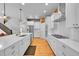 Modern kitchen with white cabinetry, sleek countertops, and stainless steel appliances open to living area at 6632 Osage St, Denver, CO 80221