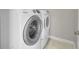 Laundry room featuring a new white washer and dryer combo, and neutral tiling at 6632 Osage St, Denver, CO 80221