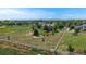 An aerial view of the residence on a large lot surrounded by a white fence, mature trees, and a play area at 14652 Kalamath Ct, Westminster, CO 80023