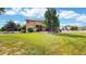 The expansive yard features a lush lawn with a patio area and mature trees, all surrounded by white fencing at 14652 Kalamath Ct, Westminster, CO 80023