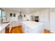 Updated kitchen with stainless steel appliances, white cabinets, kitchen island, and hardwood floors at 14652 Kalamath Ct, Westminster, CO 80023