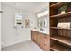 A bright bathroom with a double vanity, modern lighting, a window, and a wooden storage unit is a spa-like retreat at 2244 S Franklin St, Denver, CO 80210