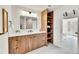 A luxurious bathroom has a double vanity with modern fixtures, a spacious countertop, and stylish shelving at 2244 S Franklin St, Denver, CO 80210