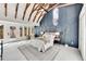 Sunlit bedroom with vaulted ceilings, exposed wood beams, accent wall, and access to the outdoors at 2244 S Franklin St, Denver, CO 80210