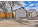 View of the home's garage showing the large driveway and wooden privacy fence at 2244 S Franklin St, Denver, CO 80210