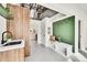 A modern mudroom with a wooden accent wall, sink, bench, and hooks for coats and bags provides a functional and stylish entryway at 2244 S Franklin St, Denver, CO 80210