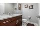 Bathroom with a single sink vanity, toilet, and decorative wall art at 6018 Beeler Ct, Denver, CO 80238