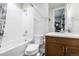 Bright bathroom with a shower-tub combo, white tile surround, and a contemporary vanity at 6018 Beeler Ct, Denver, CO 80238