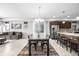 Bright dining room featuring a long wooden table, modern chandelier, and sliding glass doors for outdoor access at 6018 Beeler Ct, Denver, CO 80238