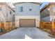Two car garage with painted door and neutral siding, framed by natural wood fencing and shrubbery at 6018 Beeler Ct, Denver, CO 80238