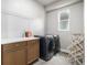 Convenient laundry room with a modern washer and dryer, counter space, and storage cabinets at 6018 Beeler Ct, Denver, CO 80238