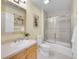 Cozy bathroom with a single sink vanity, a mirror, a toilet, and a shower/tub combination at 4704 W Hinsdale Ct, Littleton, CO 80128