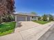 Charming home featuring a three-car garage, a long driveway, and a well-manicured lawn at 4704 W Hinsdale Ct, Littleton, CO 80128
