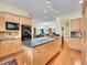 Open kitchen with center island, dark countertop, wood cabinetry, and integrated appliances for seamless living at 4704 W Hinsdale Ct, Littleton, CO 80128