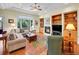 Cozy living room with a fireplace, built-in bookshelves, large windows, and comfortable seating at 4704 W Hinsdale Ct, Littleton, CO 80128
