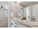 Bathroom with double sinks and vanities plus a large mirror, adjacent to the bedroom at 15131 Munich Ave, Parker, CO 80134