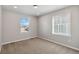 Neutral bedroom with two windows, light colored walls, and light carpeting at 15131 Munich Ave, Parker, CO 80134