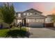 Charming two-story home featuring a covered porch, manicured lawn, and a two-car garage at dusk at 15131 Munich Ave, Parker, CO 80134