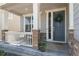 Inviting front porch with brick accents, a cozy sitting area, a wreath on the front door, and a welcome mat at 15131 Munich Ave, Parker, CO 80134