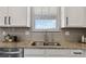 Close up on a bright kitchen featuring granite counters, tile backsplash, and stainless steel sink at 15131 Munich Ave, Parker, CO 80134
