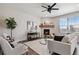 Bright living room featuring a stone fireplace, modern furniture, and sleek ceiling fan at 15131 Munich Ave, Parker, CO 80134