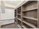 Spacious walk-in closet with dark wood built-in shelving, with overhead lighting at 665 S Alton Way # 4B, Denver, CO 80247